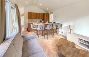 a living room with a couch and a table with chairs at Sernets Recreatie Chalet 112 in Oud-Gastel