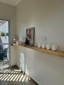 a living room with a shelf with mugs on it at Casa de Aire Ezeiza in La Unión