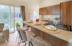 a kitchen with a counter with chairs and wine glasses at Sernets Recreatie Chalet 112 in Oud-Gastel