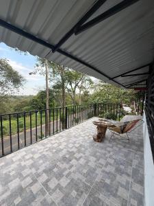 a patio with a bench and a table on a balcony at Cabaña DAYANAVA in Aguazul
