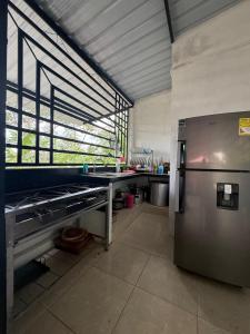 a kitchen with a refrigerator and a large window at Cabaña DAYANAVA in Aguazul