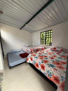 a bedroom with two beds and a window at Cabaña DAYANAVA in Aguazul