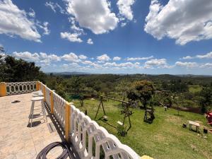 a balcony with a white fence and a view of a field at Chácara Pagliai e Bueno in Suzano