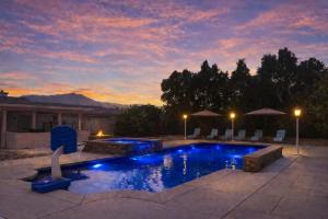 a swimming pool in a backyard at dusk at Casa Pueblo in Desert Hot Springs