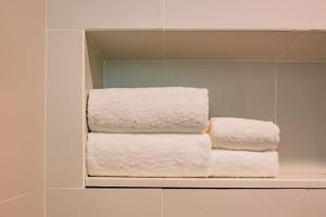 a stack of towels on a shelf in a bathroom at Ibis Chengdu High-tech Tianfu Software Park in Chengdu