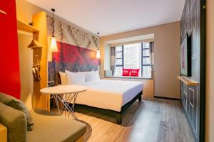 a hotel room with a bed and a table at Ibis Chengdu High-tech Tianfu Software Park in Chengdu