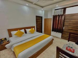 a bedroom with a large bed with yellow pillows at Hotel O Naveen Residancy in Manesar +50 photos