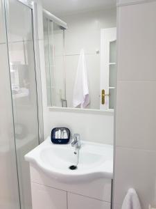 a white bathroom with a sink and a shower at Suites Garden Apartamento 33 in Las Palmas de Gran Canaria