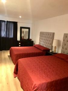 a hotel room with two beds and a mirror at Oasis Tequisquiapan in Tequisquiapan