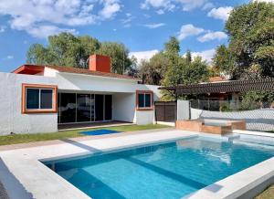 a house with a swimming pool in front of a house at Oasis Tequisquiapan in Tequisquiapan
