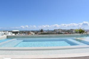 a swimming pool with a view of the ocean at Lux Condo Anah Downtown in Playa del Carmen