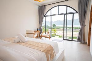 a bedroom with a large bed and a large window at Lazura Serenite in Bangli