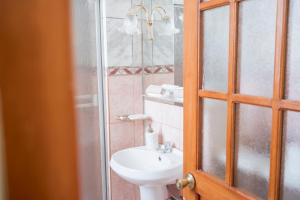 a bathroom with a sink and a glass shower at Moty's Guesthouse in Cusco