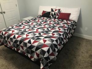 a bedroom with a black and white comforter on a bed at Utah Housing in South Jordan