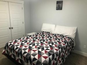a bedroom with a black and white comforter on a bed at Utah Housing in South Jordan