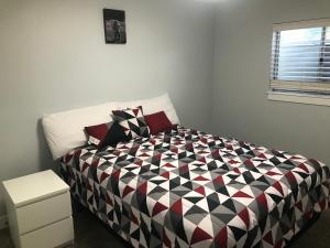 a bedroom with a black and white comforter on a bed at Utah Housing in South Jordan