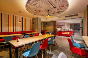 a restaurant with tables and chairs and a kitchen at Ibis Chengdu High-tech Tianfu Software Park in Chengdu