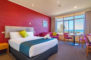 a bedroom with a large bed and a red brick wall at The Beach Hotel Whyalla in Whyalla +68 photos