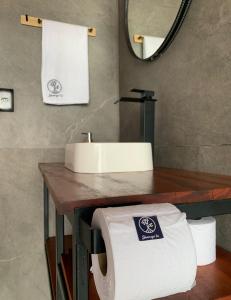 a bathroom with a sink and a roll of toilet paper at Shangri-lá Chalés in Gonçalves +102 photos