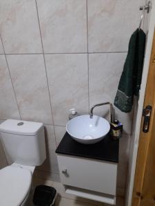 a bathroom with a white toilet and a sink at Casa Contêiner Azul in Rosário do Sul