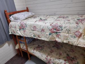 a bedroom with a bed with a flowery comforter at Casa Contêiner Azul in Rosário do Sul