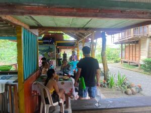 a group of people sitting at a food truck at Posada Kevelin in Termales - agua caliente - nuqui