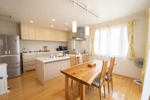 a kitchen with a wooden table and a dining room at 絆Kizuna in Yatomi 