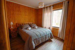a bedroom with a bed and a window at Nevisca 5p in Curacautín +2 photos