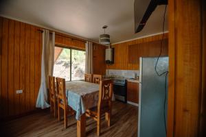 a kitchen with a table and chairs and a refrigerator at Nevisca 5p in Curacautín