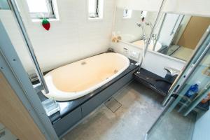 a bath tub in a bathroom with a mirror at 絆Kizuna in Yatomi  +40 photos