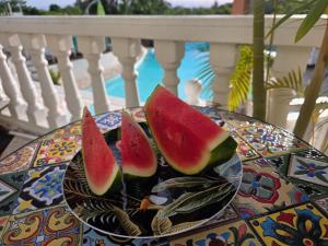 three slices of watermelon on a plate on a table at Le Paille en Queue in Saint-Louis