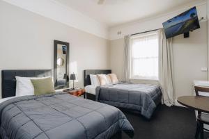 a hotel room with two beds and a tv at Hotel Gosford in Gosford +53 photos