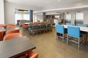 ein Esszimmer mit Tischen und blauen Stühlen in der Unterkunft Holiday Inn Express Philadelphia Penn's Landing by IHG in Philadelphia