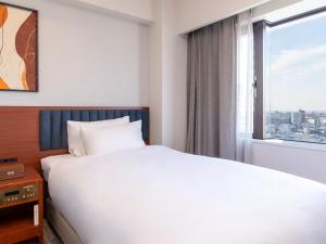 a bedroom with a white bed and a window at ANA Crowne Plaza Chiryu by IHG in Chiryu