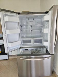 an empty refrigerator with its door open in a kitchen at Casa Adonai in Temixco