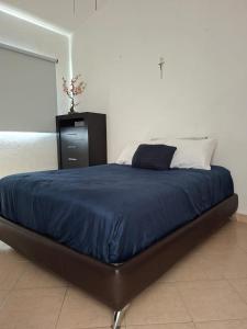 a bed with a blue blanket and a dresser in a bedroom at Casa Adonai in Temixco +40 photos