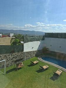 two lounge chairs and a swimming pool on a building at Casa Adonai in Temixco
