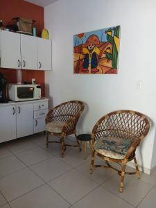 eine Küche mit zwei Stühlen und einem Gemälde an der Wand in der Unterkunft NuHostel in Conde