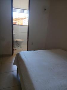 ein Schlafzimmer mit Bett und ein Badezimmer mit Toilette in der Unterkunft NuHostel in Conde