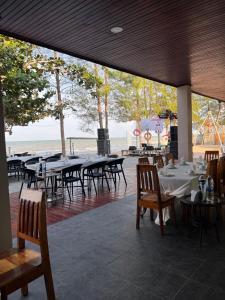 a restaurant with tables and chairs with a view of the ocean at Leamsai Beach Resort in Suratthani