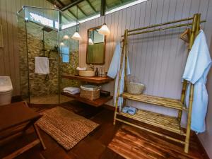 a bathroom with a shower and a sink and a mirror at The Little Hill Suite in Munduk +32 photos