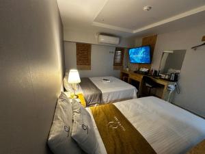 a hotel room with two beds and a desk at Orago Stay Hotel in Suwon