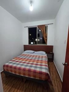 a bedroom with a bed and a window at Hostal Las Cruces II in Arica
