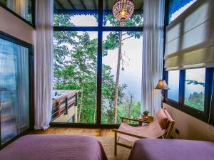 a bedroom with a large window with a view at The Little Hill Suite in Munduk