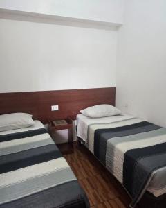 two beds in a hotel room with two beds sidx sidx sidx at Hostal Las Cruces II in Arica +2 photos