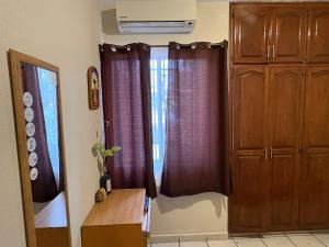 a room with a window and a wooden cabinet at Casa compartida de 1 habitación a 10 min de la playa in La Paz