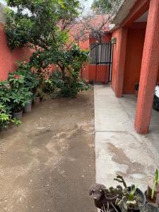 an empty courtyard of a red building with plants at Casa compartida de 1 habitación a 10 min de la playa in La Paz