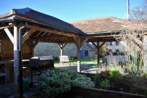 a wooden pavilion with a grill in a garden at Ash House in Wincanton