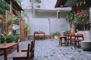 a patio with wooden tables and chairs and plants at Sita Home in Danang