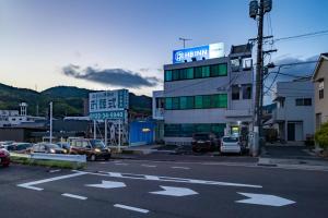 a building with cars parked in a parking lot at エイチビーイン in Hiroshima